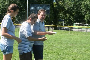 Mentor teaching his mentee to play frisbee