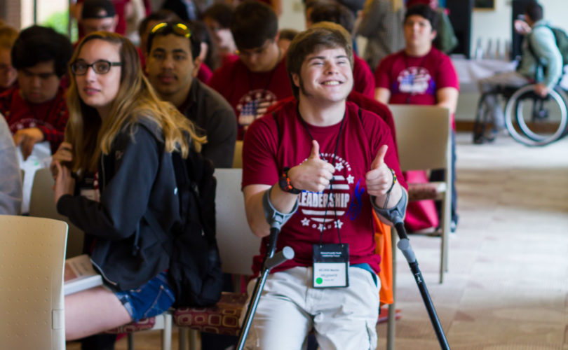 Young man that uses arm braces giving a thumbs up