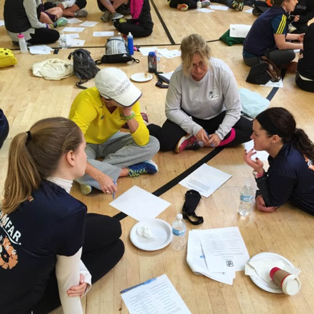 Students reviewing documents and brainstorming while sitting in a circle on the floor