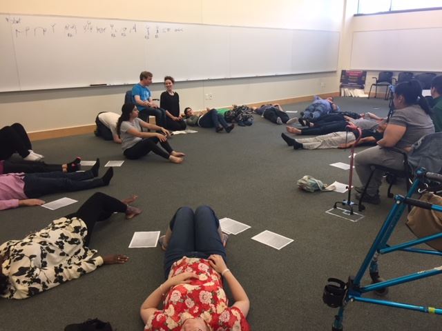 Nicole leading a circle of people in yoga