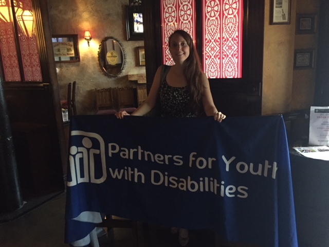 Kristin holding the PYD tablecloth banner at the Lansdowne Pub