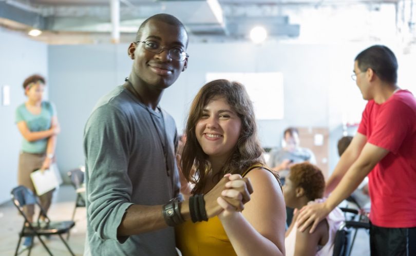 Two PYD youth pose smiling for a photo while dancing