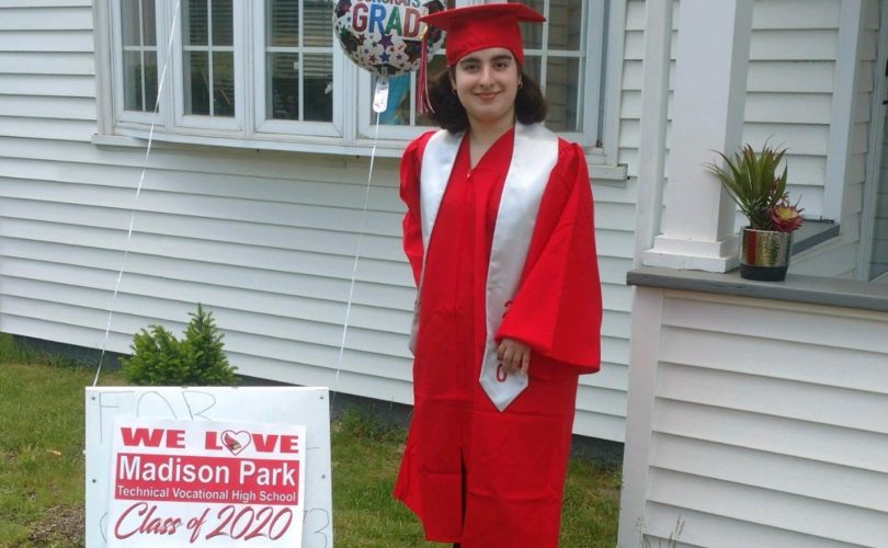 Simone wearing red cap and gown for her graduation photo