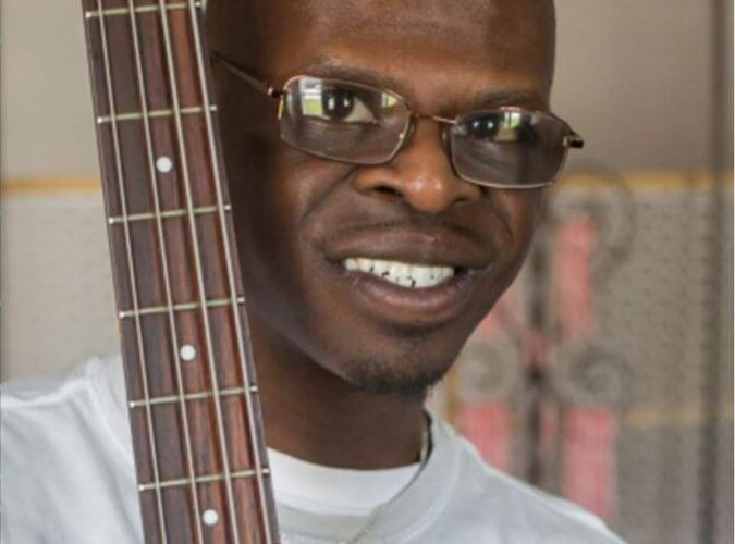 Picture of Kavon holding the stem of a guitar