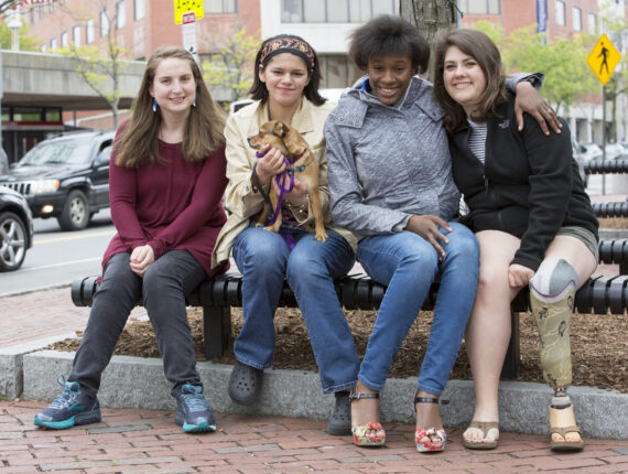 Four girls smiling with their arms around each other