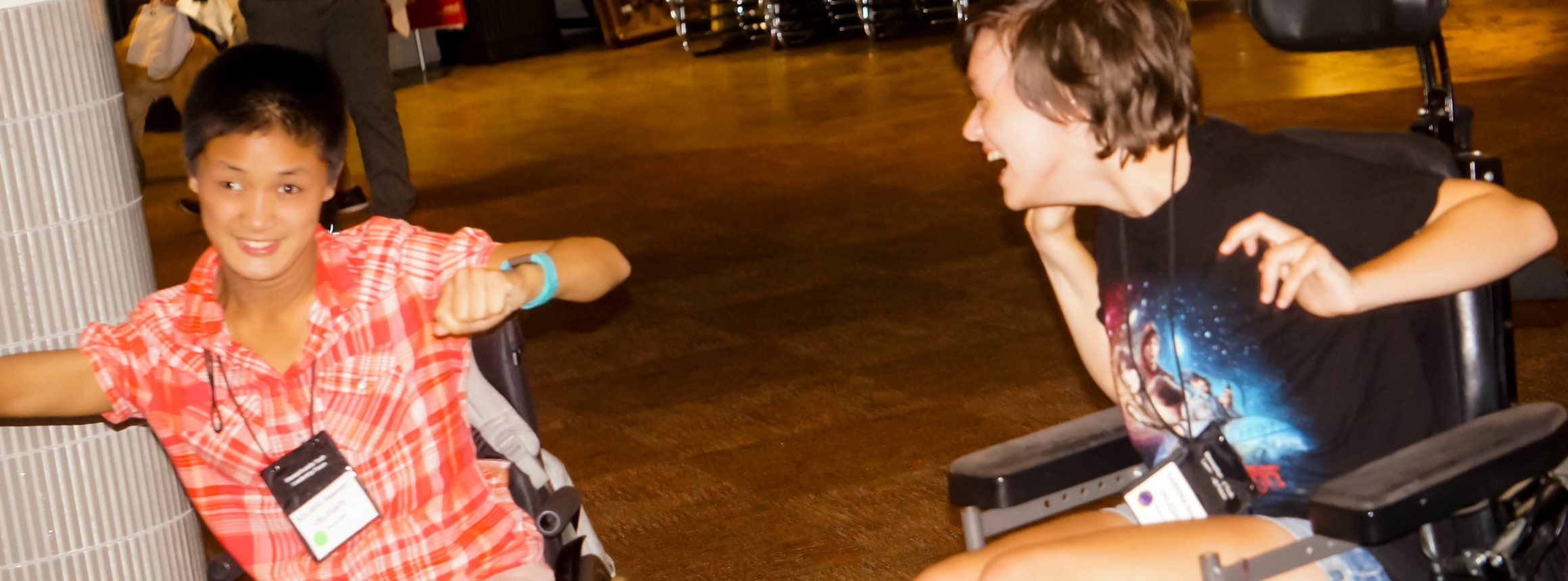 Two young women in wheelchairs dancing together