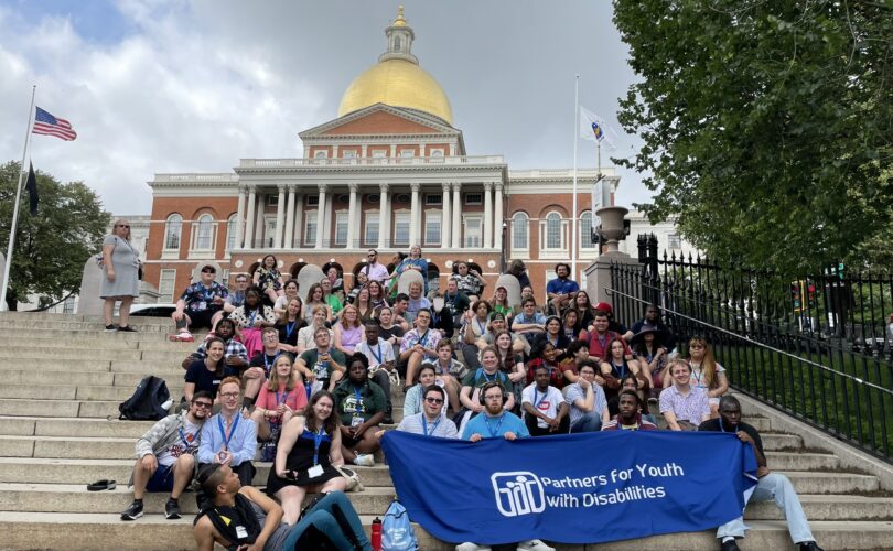 PYD participants in front of the State House with a blue PYD banner