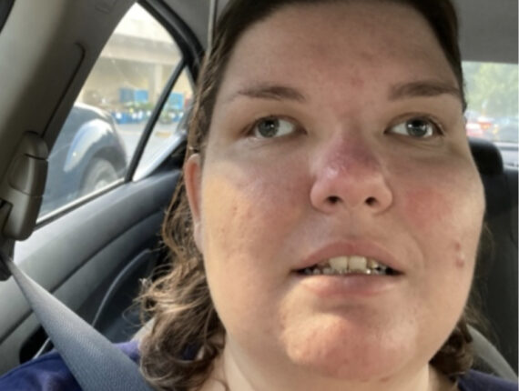 Jessie sits in a car with a seatbelt on, a navy shirt, and sunglasses on her head. 