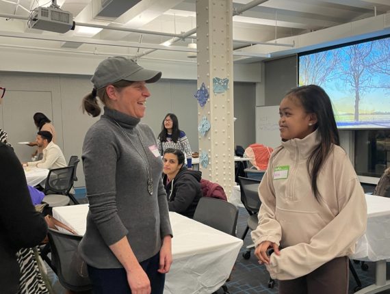 A mentor and mentee talk to each other at the winter bash.