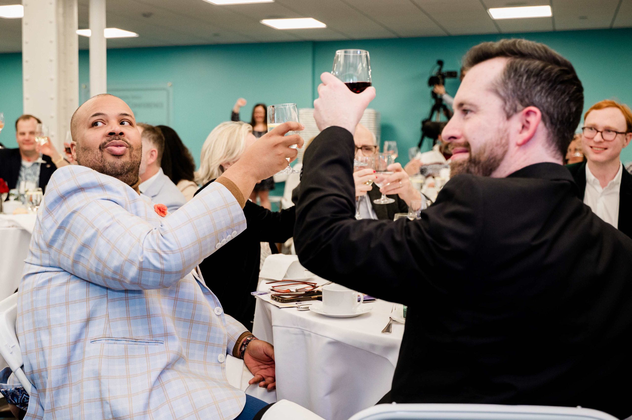 Guests at the party hold their glasses up to toast
