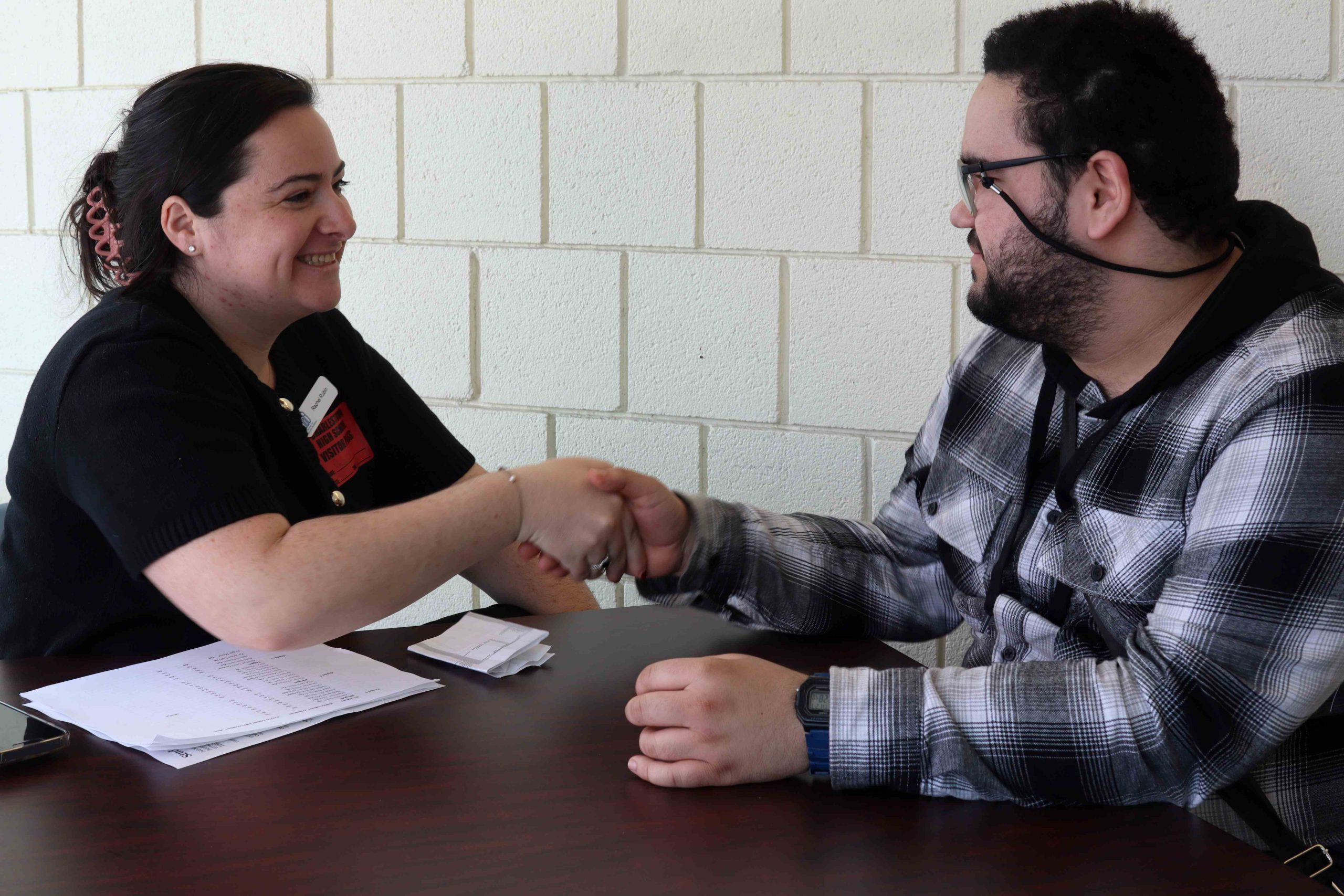 A PYD staff member (left), shakes hands with a students (right) at a mock interview.